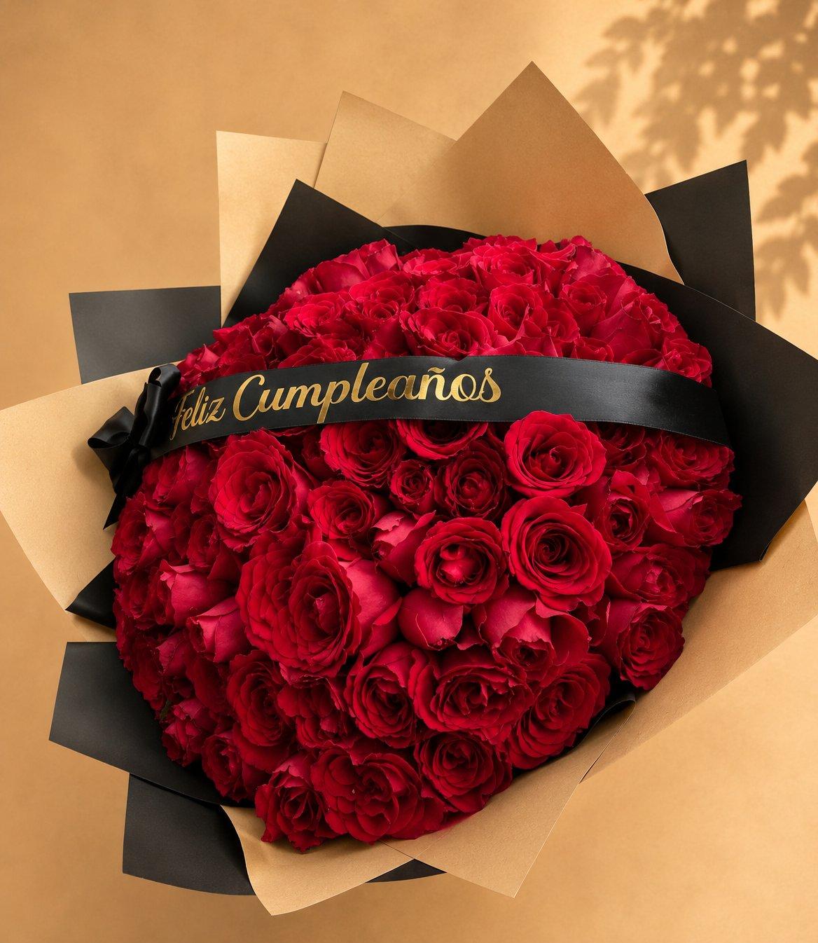 Red rose bouquet in black wrap with a Feliz Cumpleaños ribbon